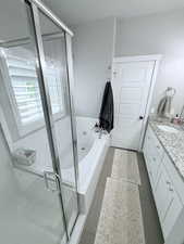 Bathroom featuring vanity, a shower stall, and a bath