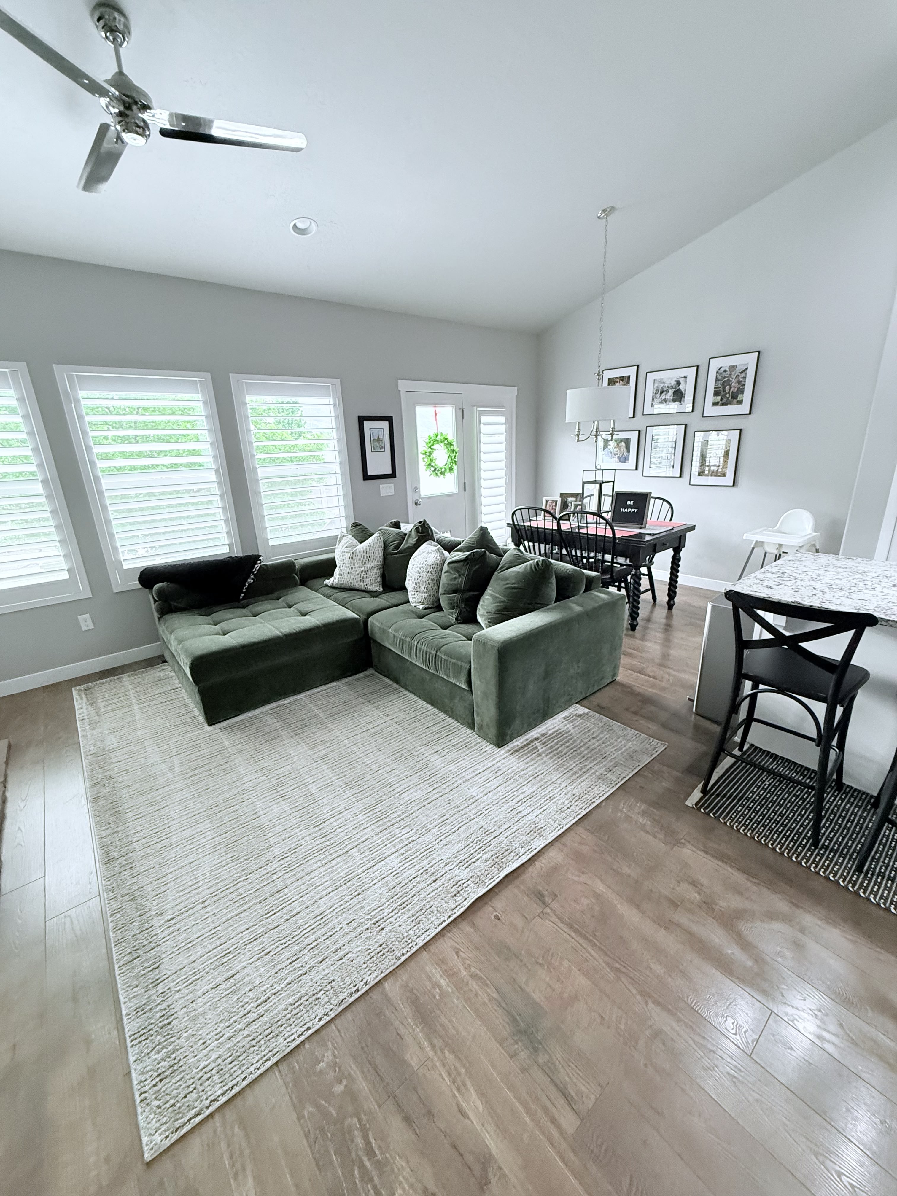 Living room featuring light wood-style floors, vaulted ceiling, and ceiling fan