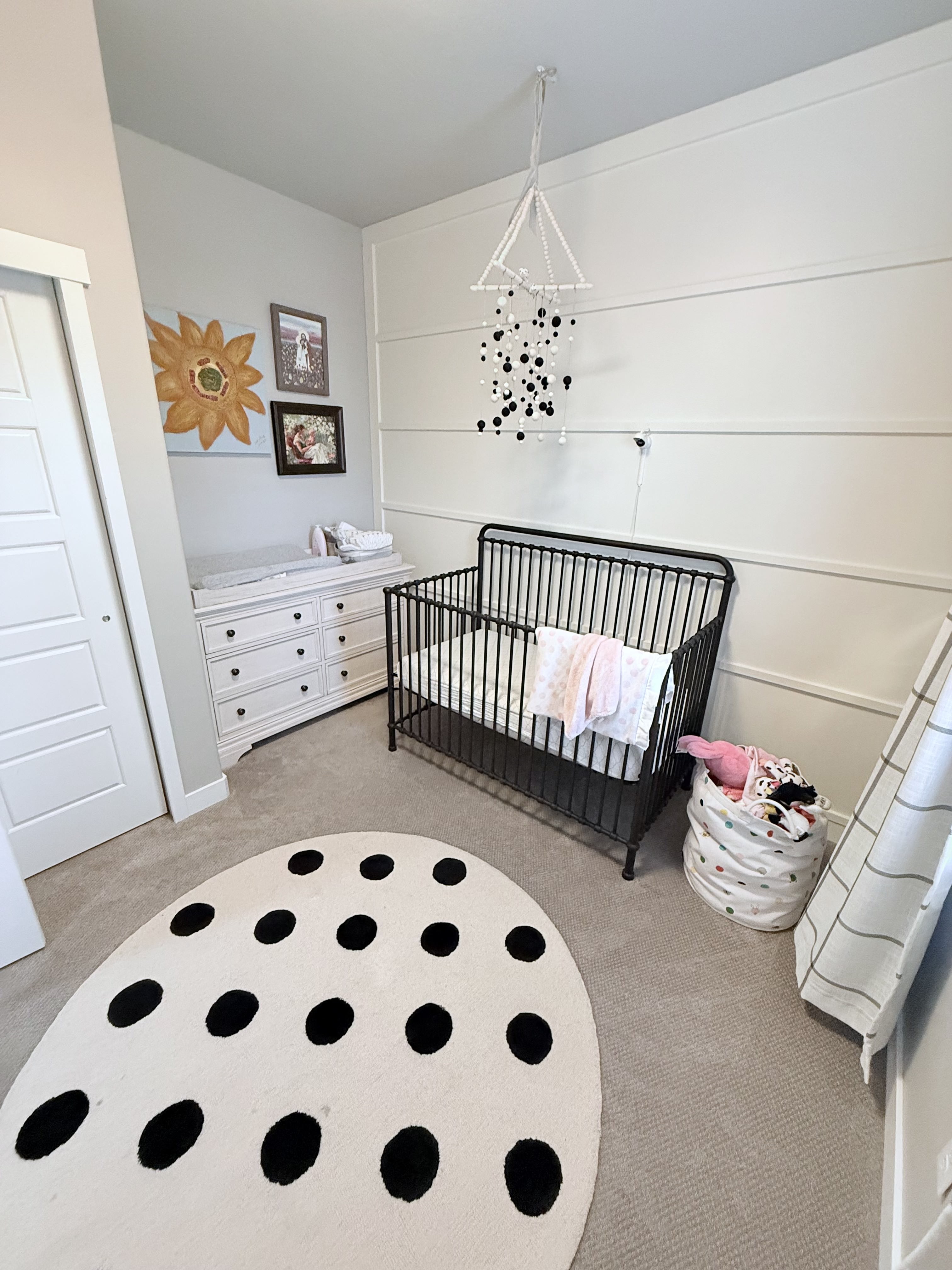 Bedroom with light carpet, a nursery area, and a closet