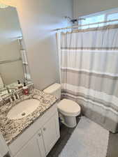 Bathroom with vanity, a shower with curtain, and dark tile patterned floors