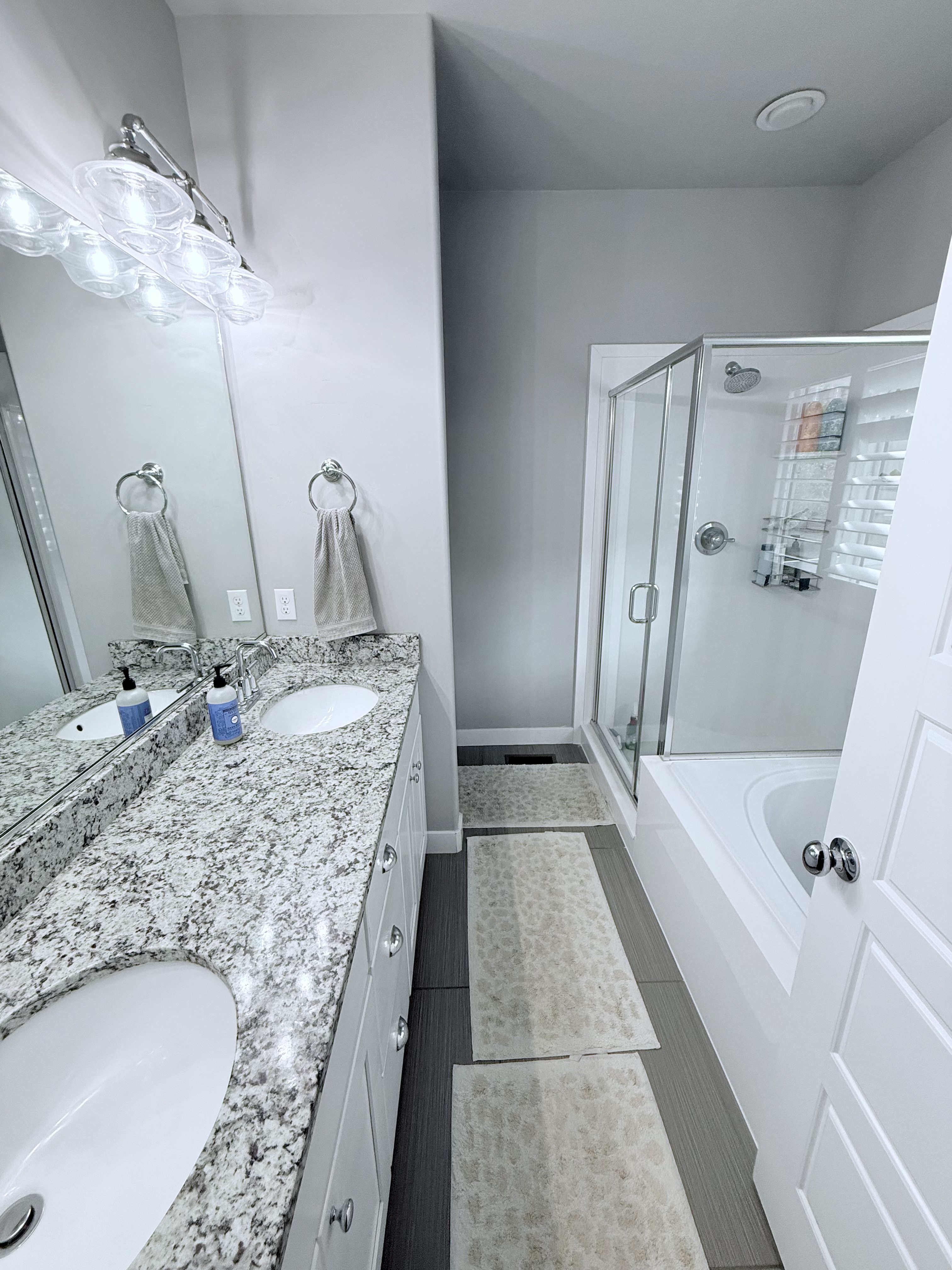 Bathroom with double vanity, a stall shower, and a bath