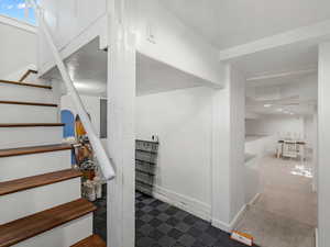 Stairs with tile patterned floors and electric panel