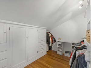 Walk in closet with vaulted ceiling and  wood-type flooring