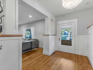Entryway featuring wainscoting, wood floors and plenty of natural light.