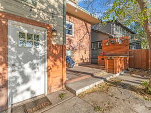 Doorway to property featuring a deck and brick siding
