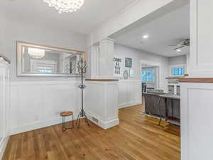 Entryway featuring wainscoting, wood floors and plenty of natural light.