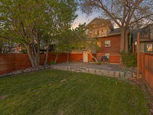 Backyard at dusk featuring a patio and summer kitchen area