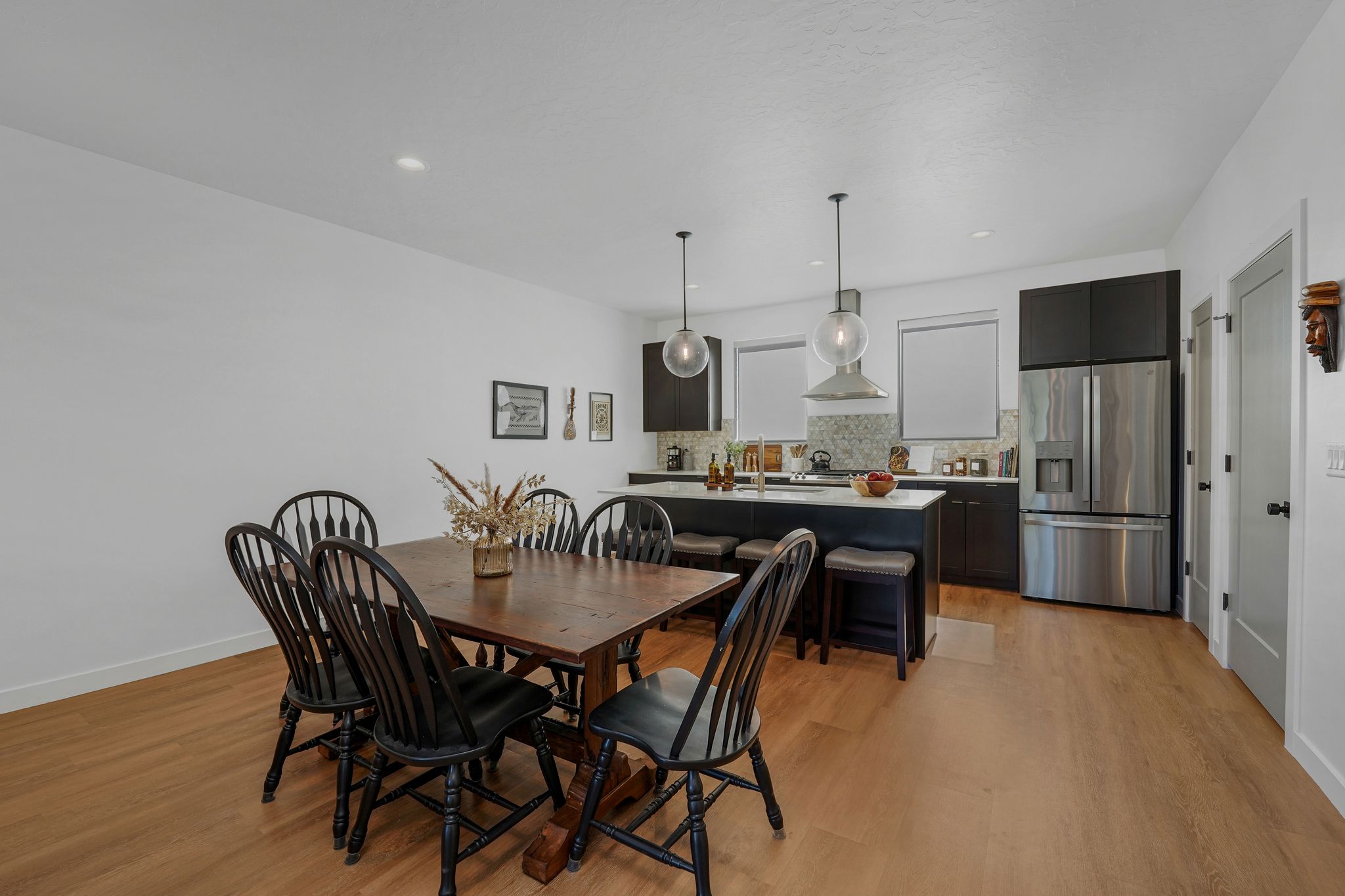 Dining room with light wood-style flooring and recessed lighting