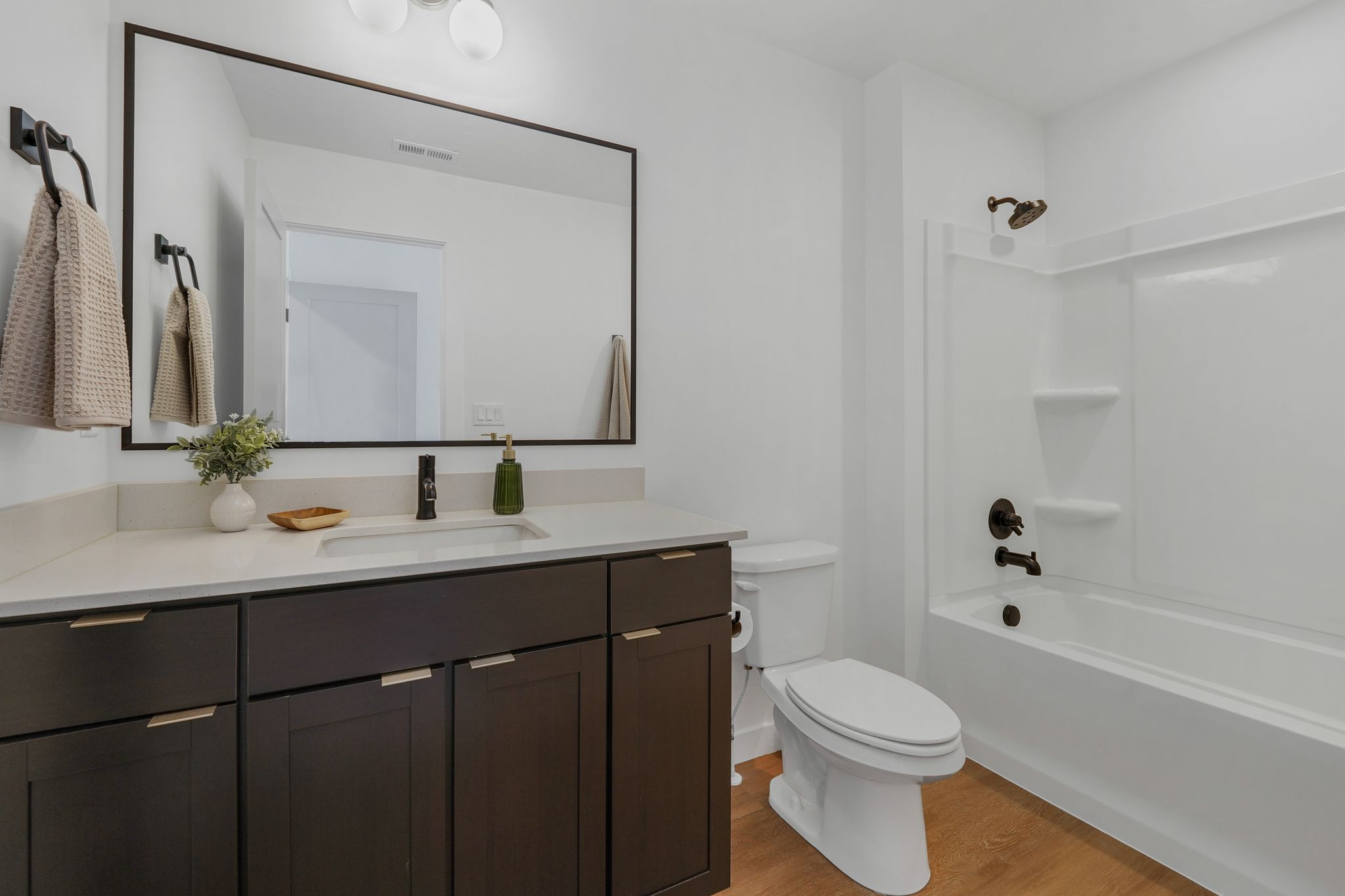 Full bath with vanity, light wood finished floors, and shower / bath combination