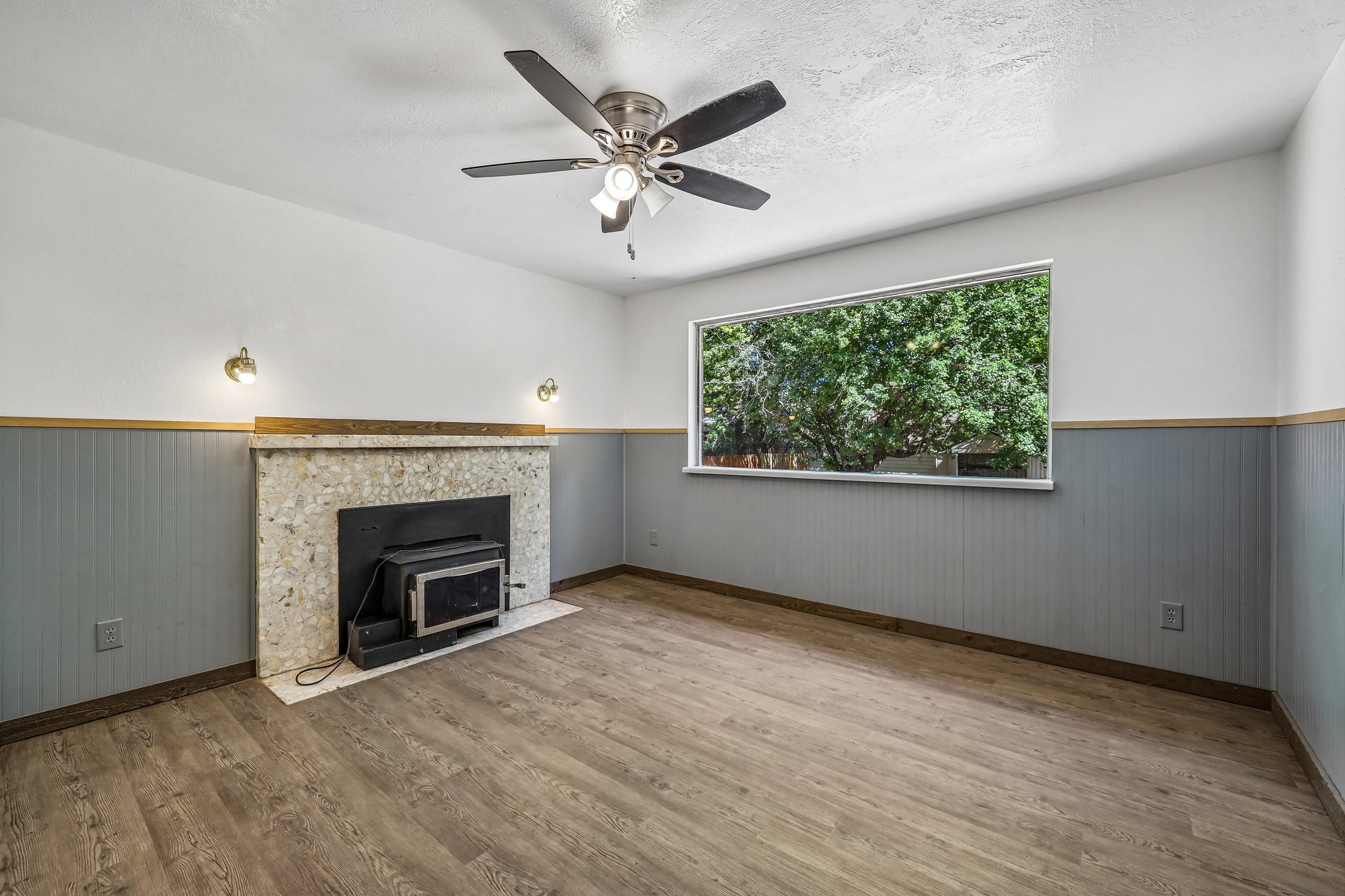 Living space featuring a stone-clad fireplace with an integrated wood-burning insert