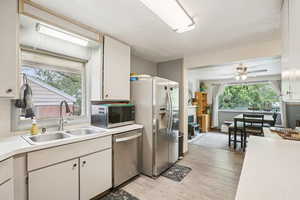 Kitchen featuring a ceiling fan, light countertops, stainless steel appliances, light wood finished floors, and plenty of natural light