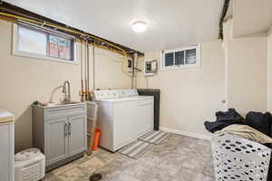 Laundry area featuring washer and dryer, electric panel, and cabinet space