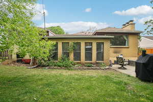 Back of house with a patio, brick siding, and a chimney