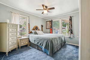 Bedroom featuring dark carpet, ceiling fan, a textured ceiling, and ornamental molding
