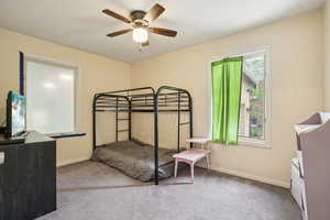 Bedroom with light colored carpet and ceiling fan