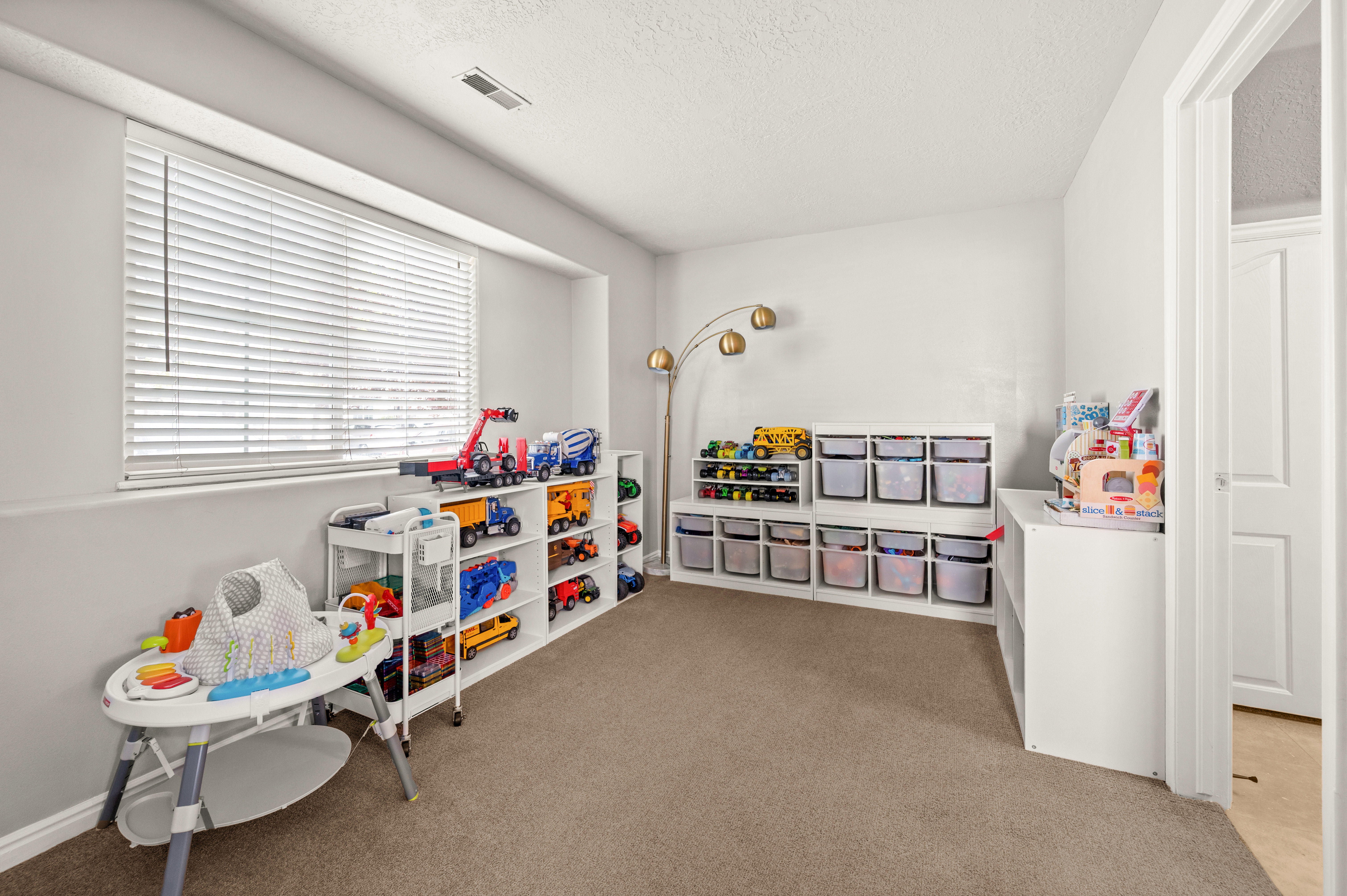 Rec room with light colored carpet and a textured ceiling