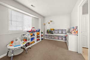 Rec room with light colored carpet and a textured ceiling