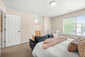 Carpeted bedroom featuring connected bathroom and a textured ceiling