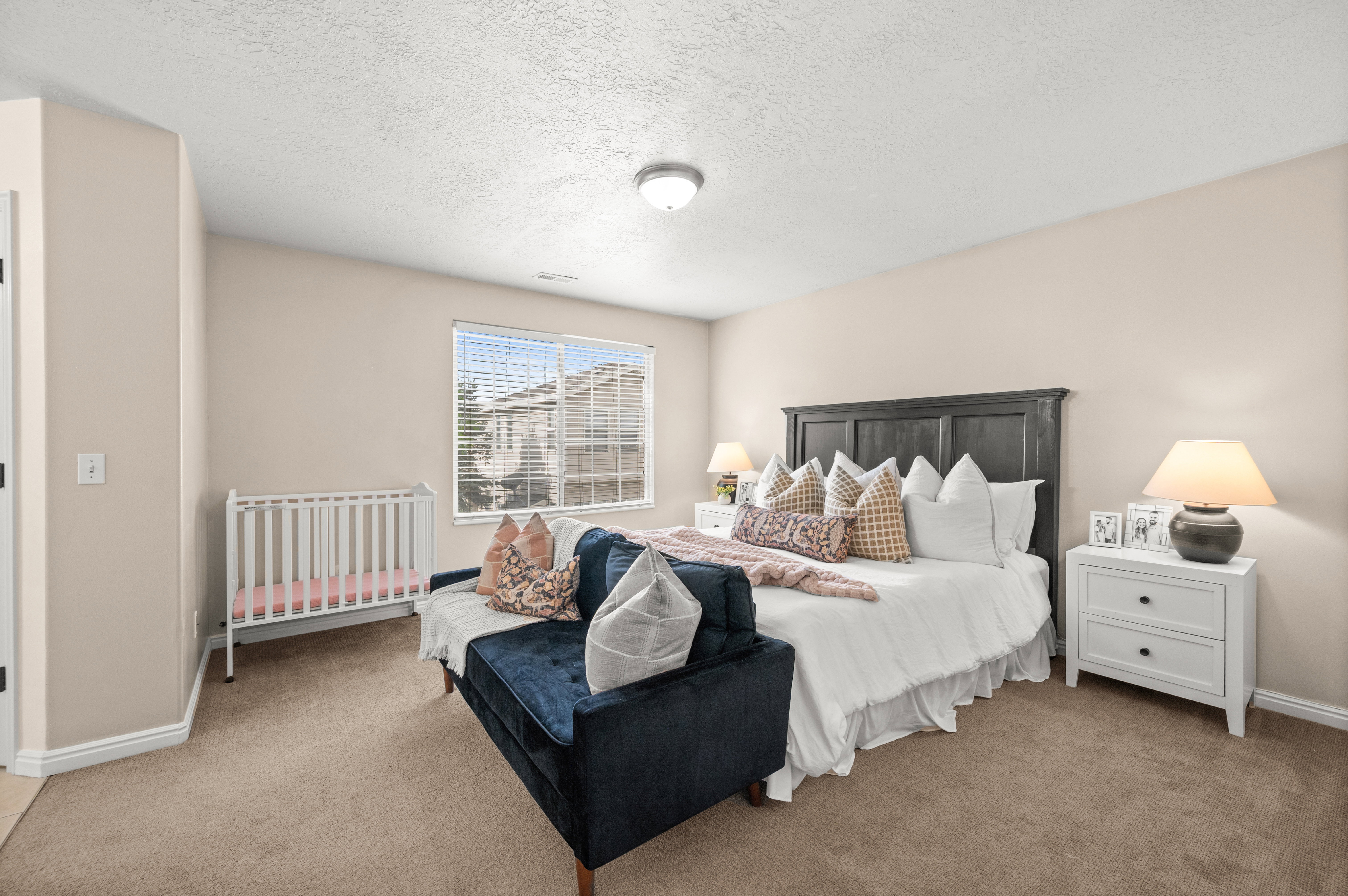 Carpeted bedroom featuring a textured ceiling and baseboards