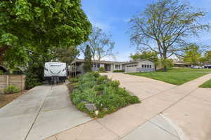 Ranch-style home with concrete driveway, a front yard, and a garage
