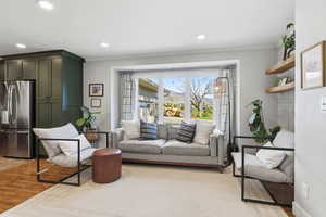 Living area featuring light wood finished floors, crown molding, and recessed lighting