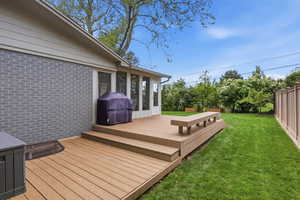 Wooden deck featuring a fenced backyard and grilling area