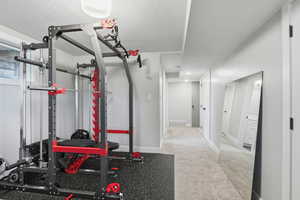 Exercise room with a textured ceiling and light carpet