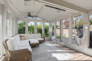 Sunroom / solarium with ceiling fan, lofted ceiling with beams, and outdoor seating