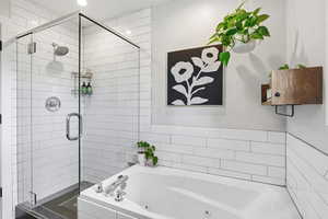 Bathroom with a shower stall and a whirlpool tub