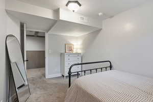 Bedroom featuring light colored carpet and a textured ceiling