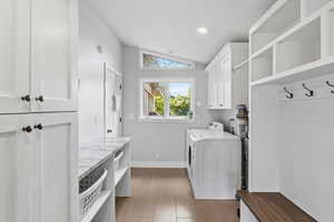 Laundry room with vaulted ceiling, cabinet space, separate washer and dryer, and recessed lighting