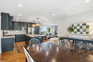 Dining room featuring recessed lighting, light wood-style floors, and ornamental molding
