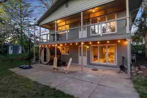 Back of property featuring a balcony, brick siding, and a yard
