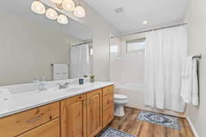 Full bathroom featuring vanity, light wood finished floors, and shower / tub combo with curtain