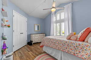 Main floor bedroom with vaulted ceilings and large windows.