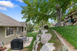 View of green lawn featuring a patio area