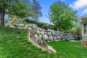 View of grassy yard featuring a patio