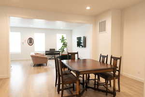 Dining area with recessed lighting and light wood-style floors