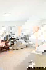 Bedroom featuring light carpet and a crib