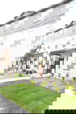 View of front facade with a front yard and stucco siding