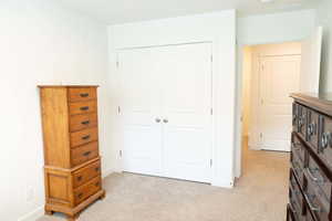 Bedroom with a closet and light colored carpet
