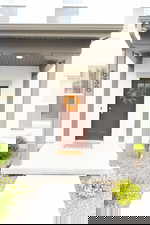 Doorway to property featuring a porch and stucco siding