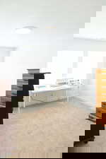 Home office with light colored carpet and baseboards