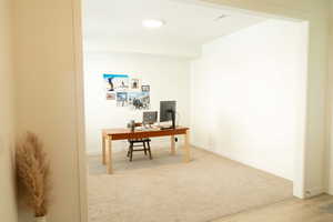 Office space featuring light colored carpet and baseboards