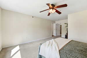 Bedroom with light colored carpet and a ceiling fan