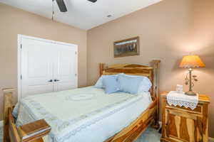 Bedroom featuring a closet, ceiling fan, and carpet flooring