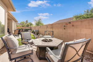 Fenced backyard featuring a patio and an outdoor fire pit