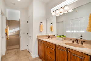 Bathroom featuring double vanity and baseboards