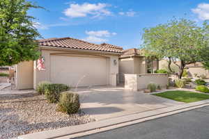 Mediterranean / spanish house featuring a gate, driveway, stucco siding, a garage, and a tile roof