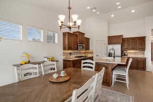 Dining space with a chandelier, light wood-style floors, and a high ceiling